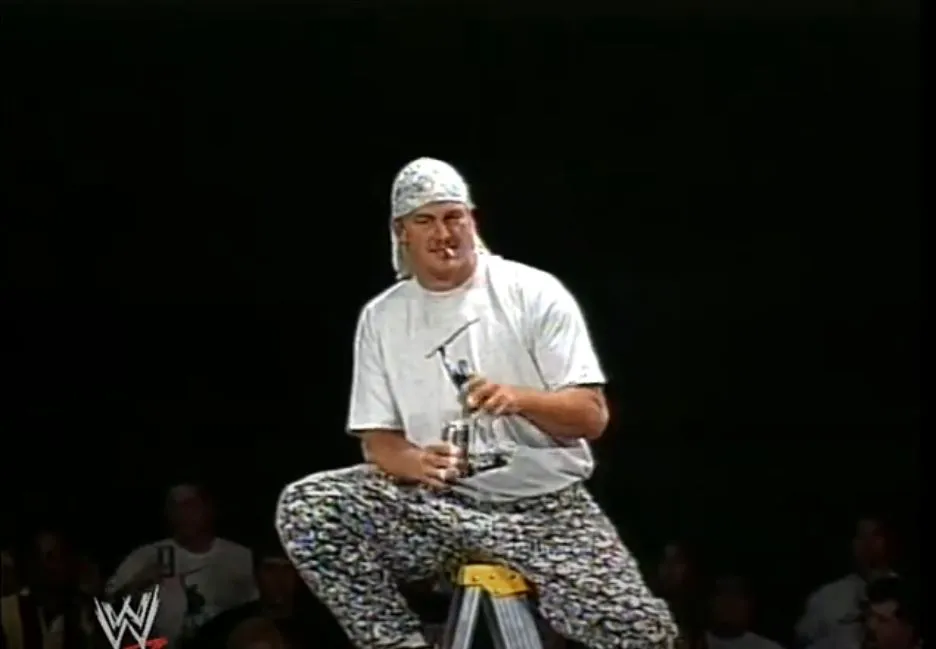 Mikey Whipwreck sits on a ladder