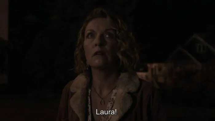 Carrie looks at the Palmer house as the stands in the street.