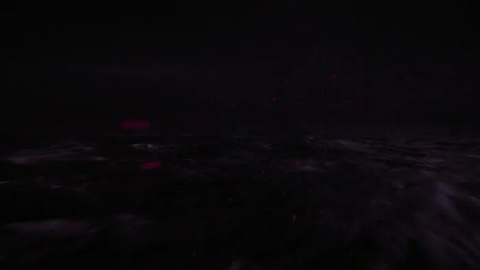 Red flecks of light scattering across the purple ocean under the Fireman's palace.