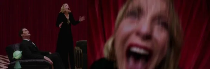 Laura ascends from the Red Room screaming, as Cooper watches.