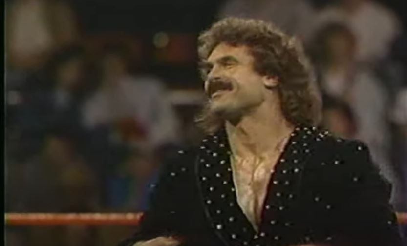 Rick Rude stands in the ring