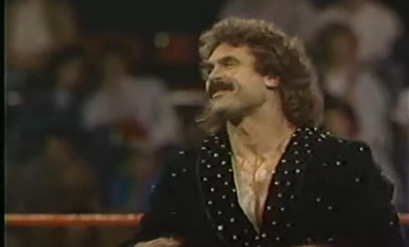 Rick Rude stands in the ring