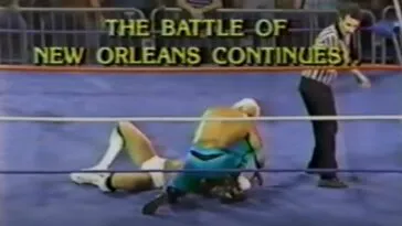 Two wrestlers in the ring with the words The Battle of New Orleans Continues After this time out!