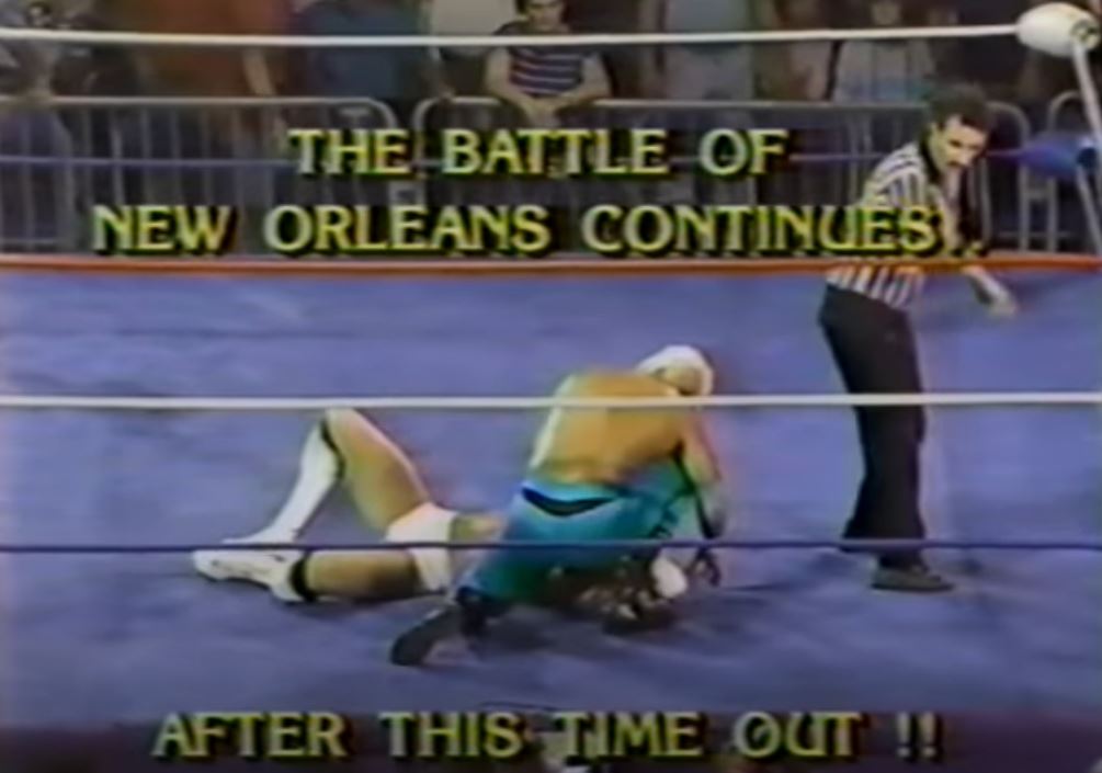 Two wrestlers in the ring with the words The Battle of New Orleans Continues After this time out!