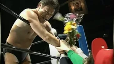 Antonio Inoki leans over the ropes for a bouquet of flowers