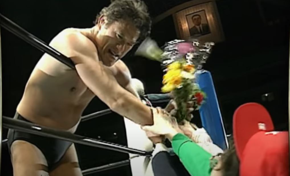 Antonio Inoki leans over the ropes for a bouquet of flowers