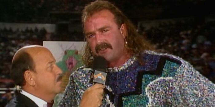 Jake Roberts conducts an interview dressed in a blue, green, and grey jumper.