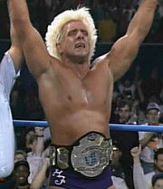 Ric Flair has his hand raised as he displays his newly won Heavyweight title belt at Starrcade '93