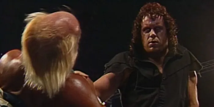An eye-rolling 'Taker throttles Hogan in the corner.