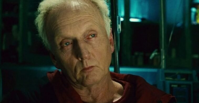 John Kramer (Jigsaw) engaging in a conversation to someone off-screen