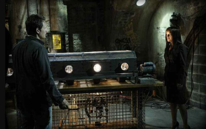 The 'ten pints of blood' trap from Saw V, with two participants stood next to it