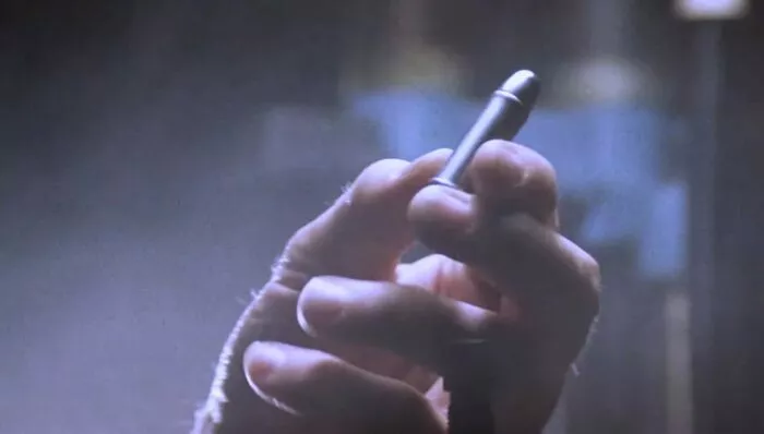 A hand holding a silver bullet