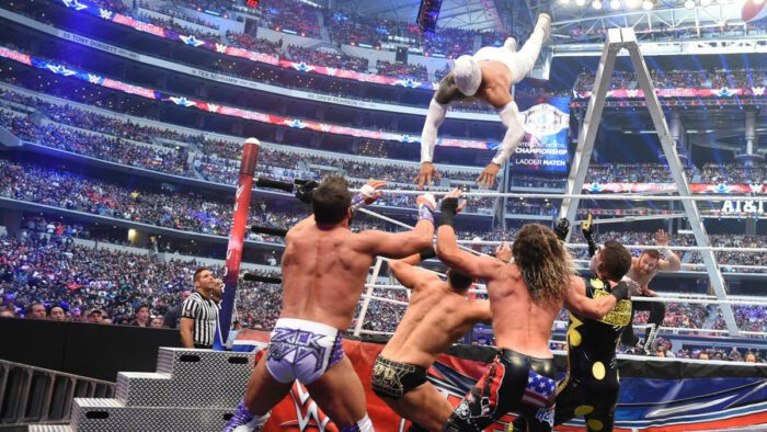 Sin Cara throws himself over the ropes onto the mass of bodies at ringside