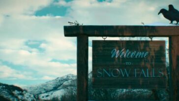 A large wooden sign with two crows sitting atop it says "Welcome to Snow Falls."