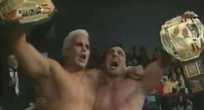 Chris Candido and Johnny Hotbody celebrate with the tag belts after a victory.