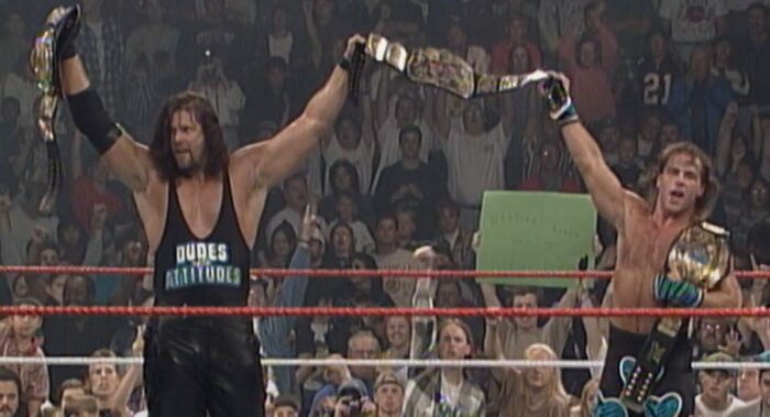 Kevin Nash and Shawn Michaels collectively hold up three title belts after winning a winner takes all title match at In Your House 3.