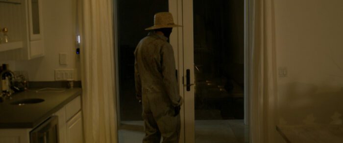 The killer standing by a door