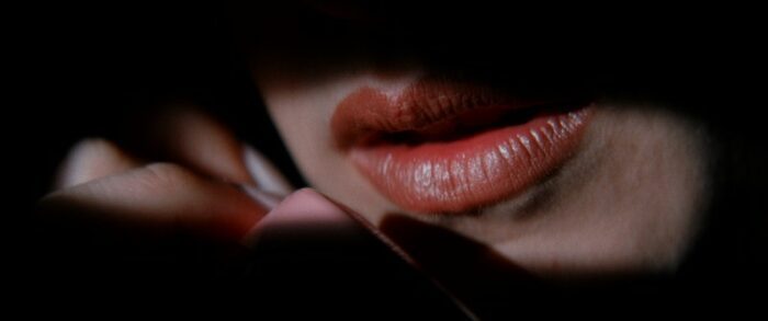 A close-up of a woman's lips, painted a shade of red