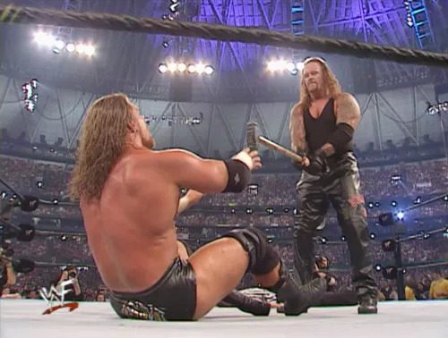 Undertaker prepares to nail Triple H with the sledgehammer at WrestleMania X7