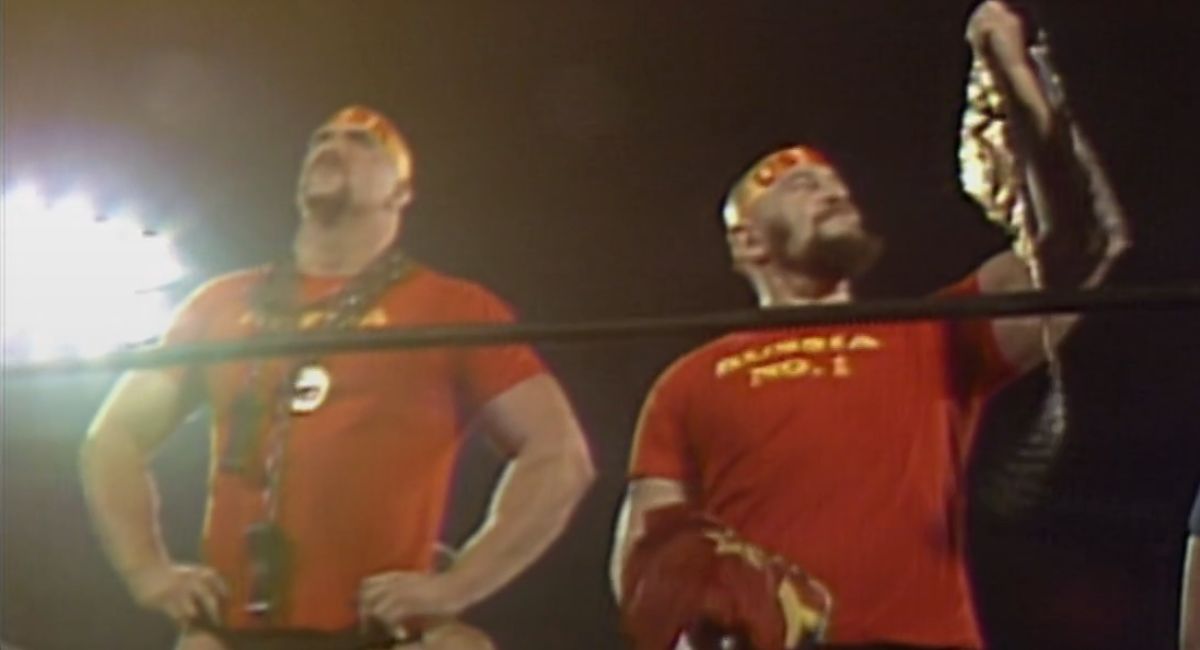 Ivan Koloff admires his tag team title belt while Nikita Koloff looks on