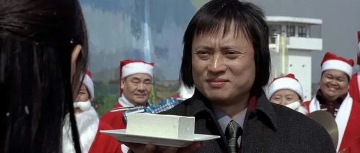 A man holding a plate of tofu