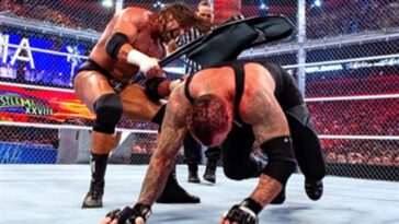 Triple H slams a chair on the back of The Undertaker during their steel cage match at WrestleMania
