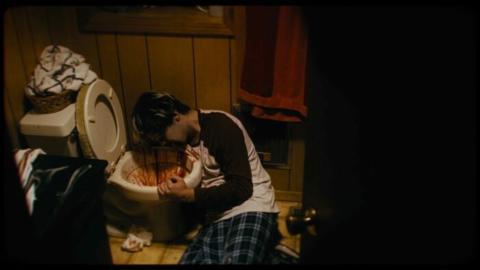 A man throwing up blood into a toilet