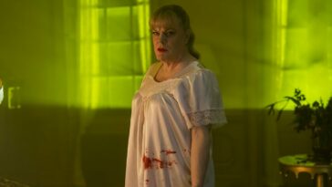 Nina is seen in the yellow light while wearing a bloody nightgown