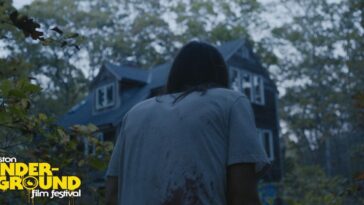 A bleeding man approaches a house through the woods in Strange Kindness