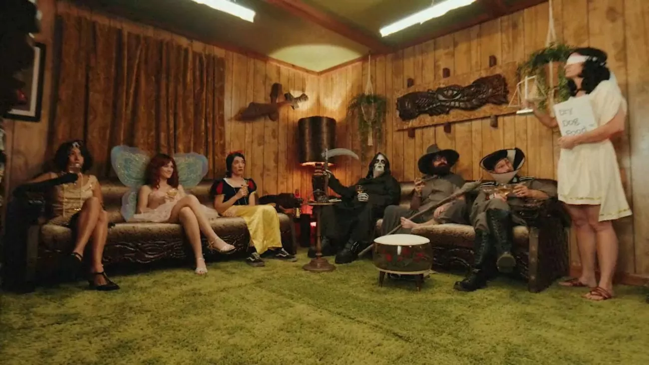 Mythical creatures and storybook characters sit in what looks like a waiting room. among them are Death, a fairy, and Snow White.