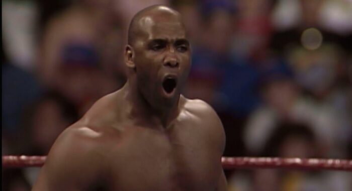 Virgil shouts at someone unseen at ringside