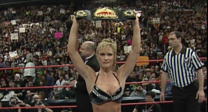 Sable holds up the WWF Women's Championship belt.