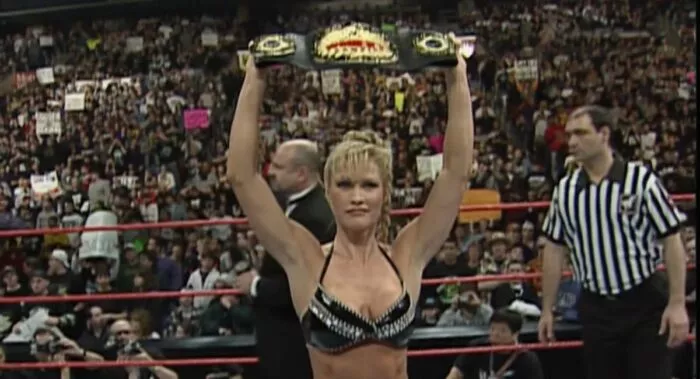 Sable holds up the WWF Women's Championship belt.