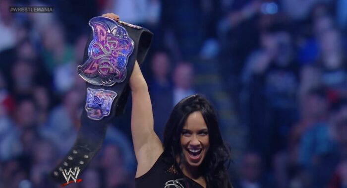AJ Lee holds up the Divas Championship belt.