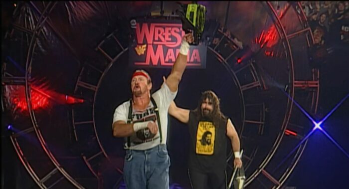 Terry Funk and Cactus Jack make their entrance at WrestleMania XIV, chainsaw in hand