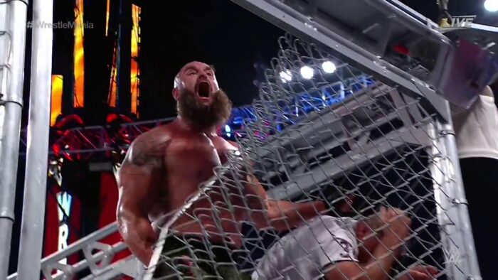 Braun Strauman grabs a cowering Shane McMahon as the steel cage is torn at WrestleMania 37