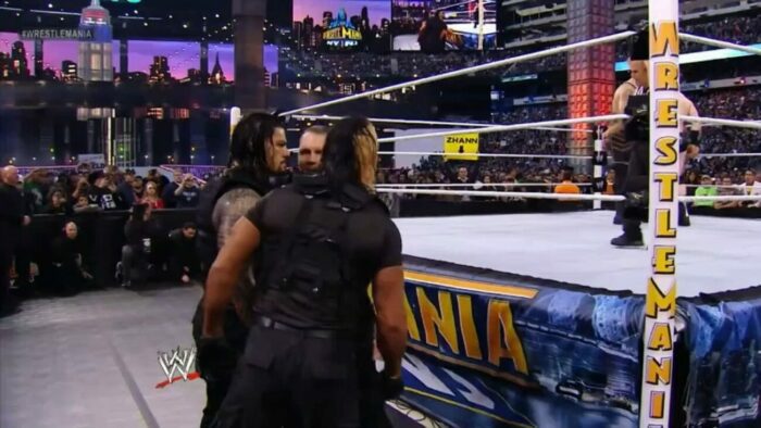 Roman Reigns and The Shield confer at ringside at WrestleMania 29