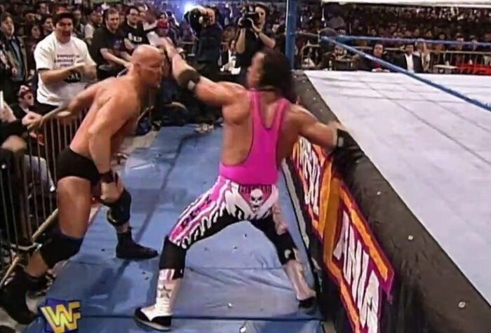 Bret Hart takes a swing at Steve Austin outside the ring at WrestleMania 13
