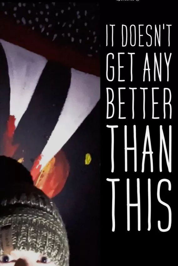 a woman in a grey winter sock hat stands below a painting of bloody teeth in the poster for IT DOESN"T GET ANY BETTER THAN THIS