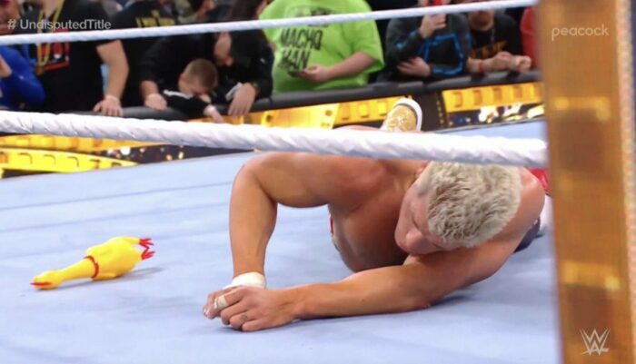 Cody Rhodes lying in the ring after losing to Reigns at Wrestlemania 38, with a rubber chicken lying next to him
