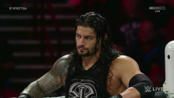 Roman Reigns resting his arms on the ropes, stood in the corner of the ring