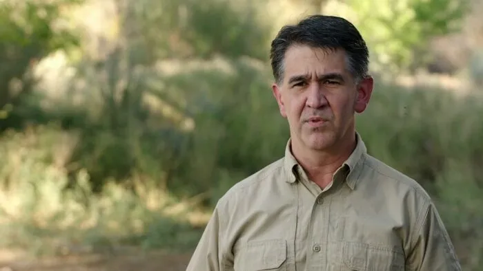 Erik Bard stands in front of brush 