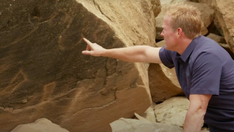 Dr. Travis Taylor points to a petroglyph on the side of the Mesa