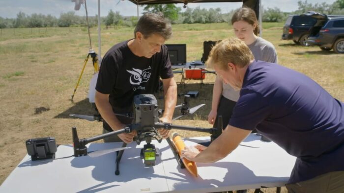 Travis, Kalista, and Jim affix the multi-sensor device to his LIDAR drone