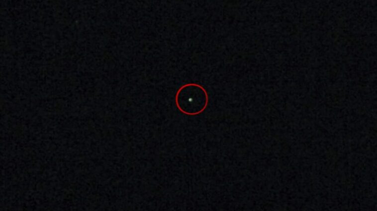 A still image of the flashing light seen in the sky, the light is circled