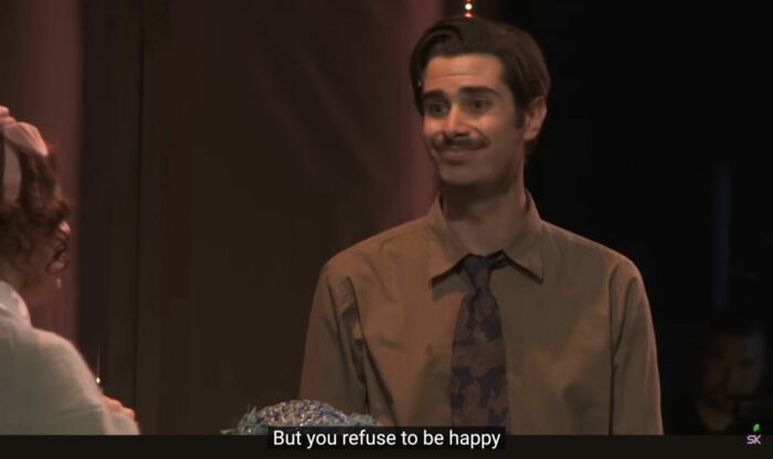 Ted Spankoffski (Joey Richter) says to Charlotte Sweetly (Jaime Lyn Beatty), "But you refuse to be happy," in the musical, "The Guy Who Didn't Like Musicals."