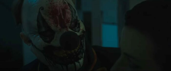 A closeup of a man wearing a bloody clown mask
