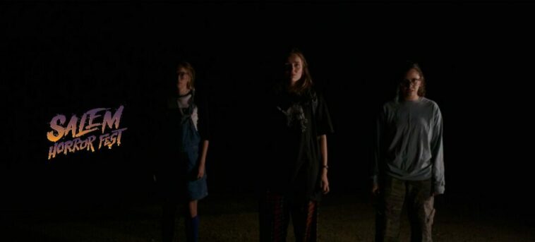 Three teenage girls are barely visable as they emerge from darkness in Sweet Relief
