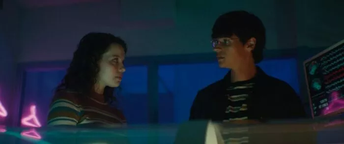 A girl and a boy and glasses exchange glances in Somnium.