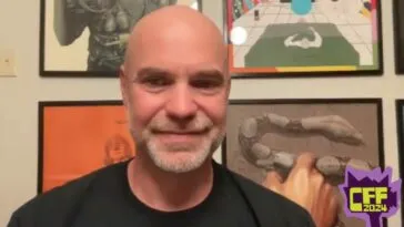 A man standing in front of a wall of posters